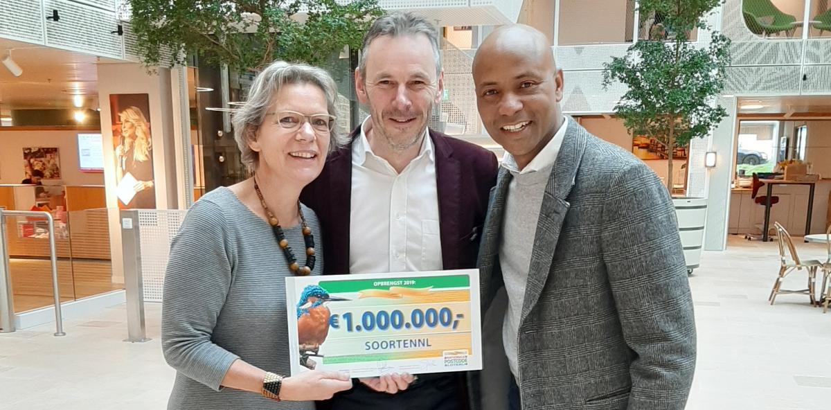 Titia Wolterbeek (SoortenNL en Vlinderstichting) en Rob van Westrienen (RAVON/FLORON en SoortenNL) met Umberto Tan na overhandiging van de cheque van de Nationale Postcode Loterij.